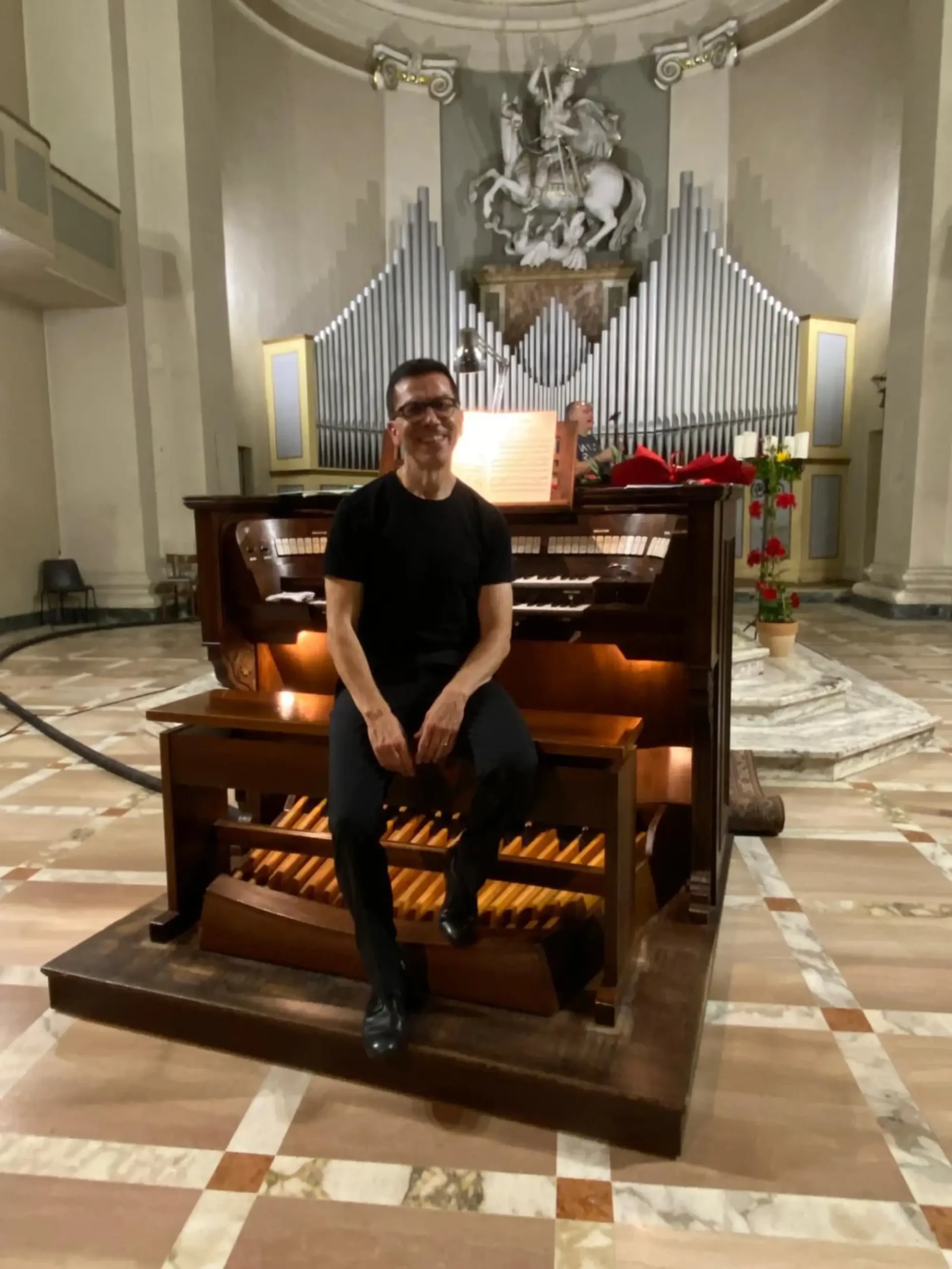 Mario Ciferri all'organo, con la facciata di canne alle spalle