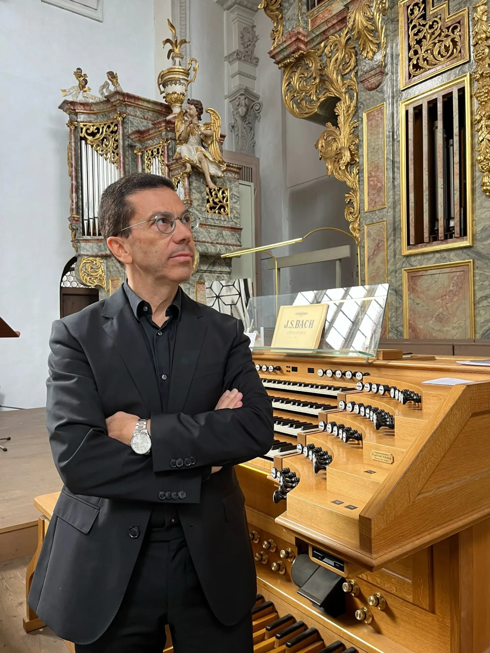 Mario Ciferri alla consolle, luce radente sulle canne dell'organo