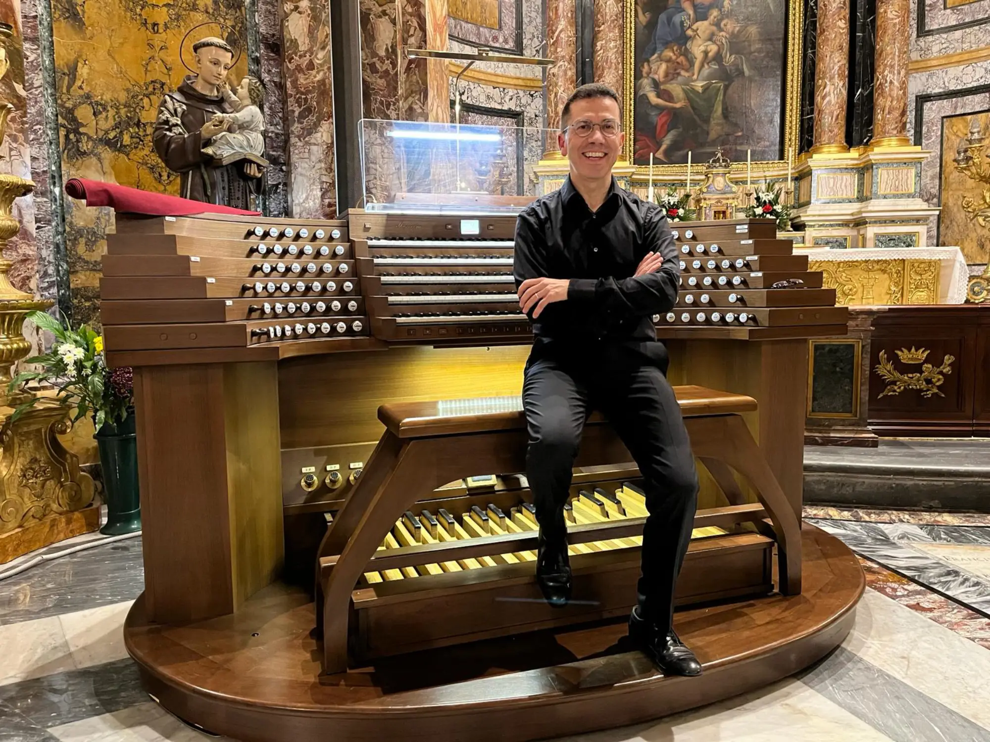 Mario Ciferri all'organo, ripreso di profilo alla consolle